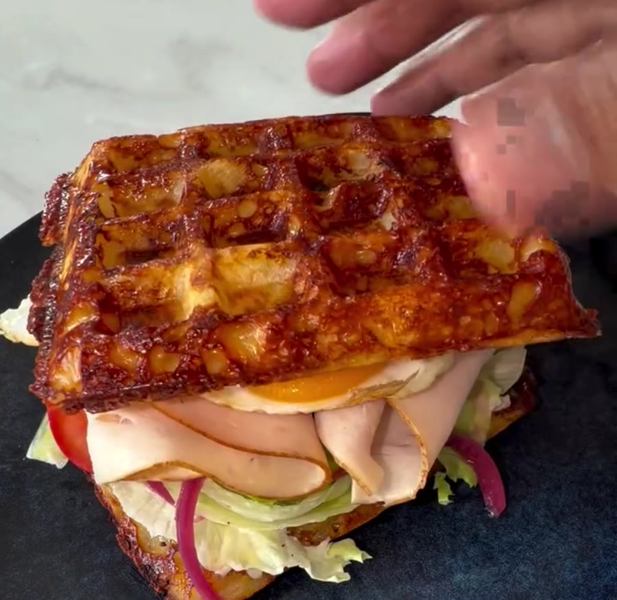 Sandwich garni de poulet, crudités et œuf entre deux gaufres dorées de pommes de terre