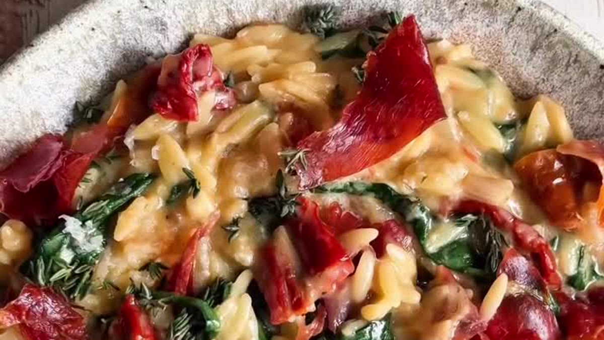 Orzo crémeux aux tomates séchées et aux épinards, garni de jambon cru croustillant