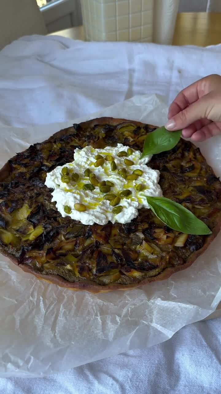 Tarte dorée aux poireaux caramélisés garnie de burrata, de pistaches et de basilic