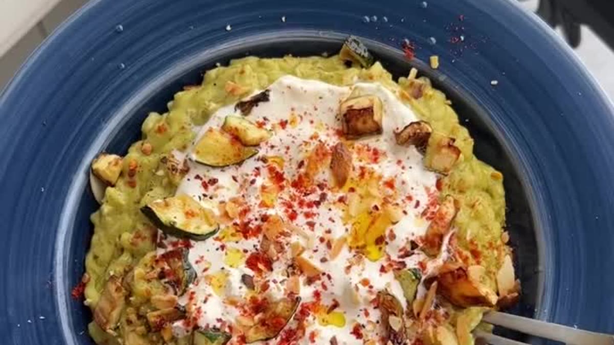 Risotto vert aux courgettes garni de burrata, de courgettes rôties et d’amandes effilées